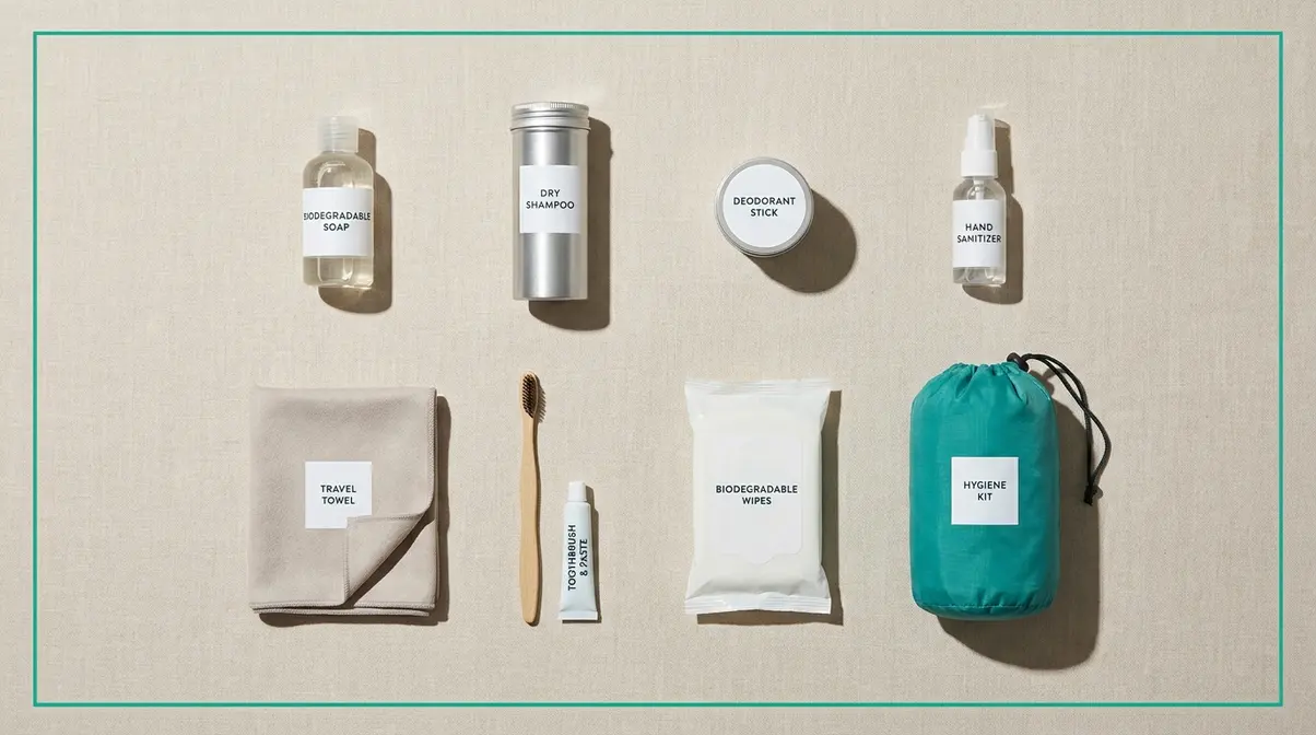 Flat-lay of compact camping hygiene kit items including biodegradable soap, wipes, and microfiber towel