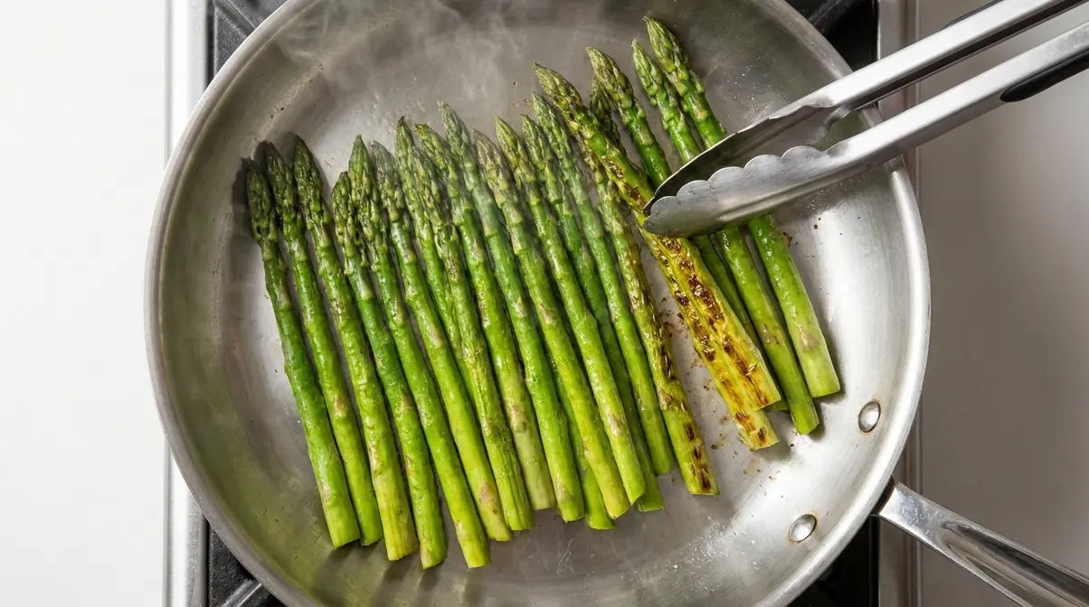 How To Cook Asparagus In A Pan: 5-Step Skillet Guide 6 Asparagus spears in a single layer in a stainless steel skillet with visible char spots