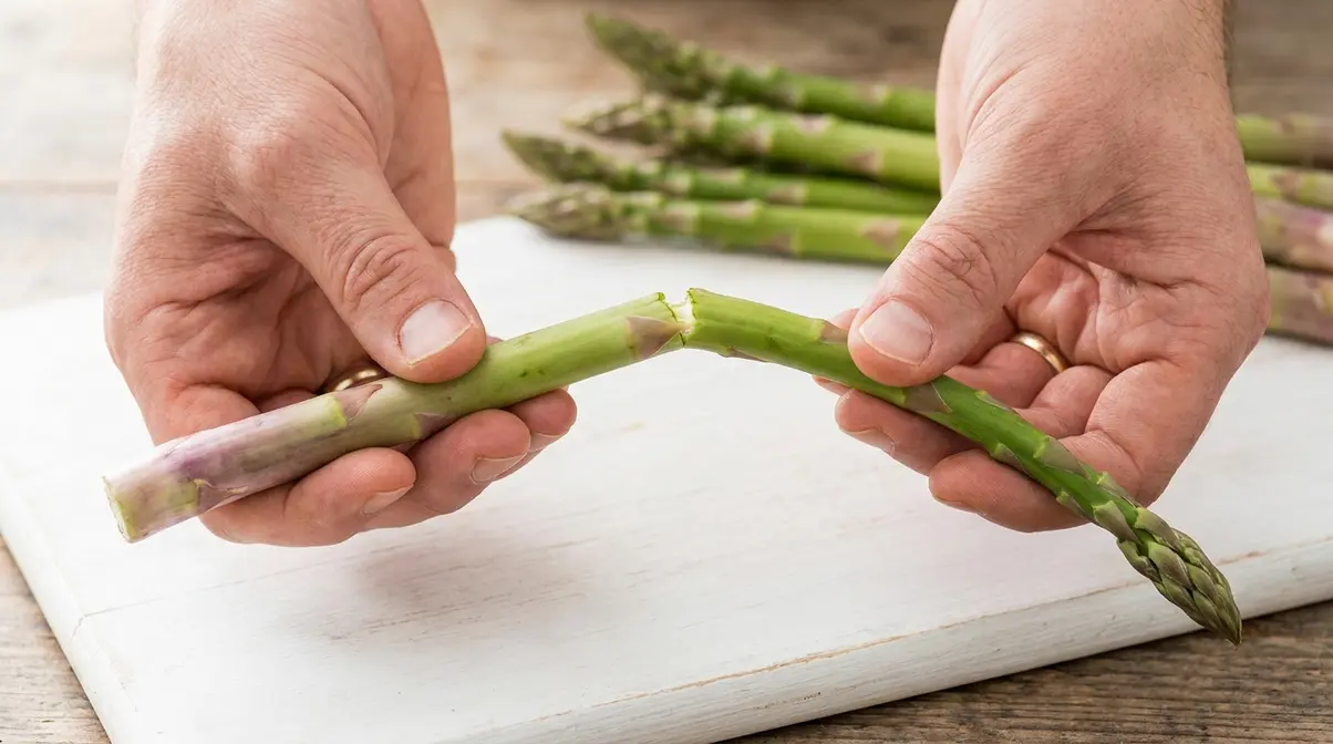 How To Cook Asparagus In A Pan: 5-Step Skillet Guide 3 Hands bending a single asparagus spear to find the natural snap point for trimming