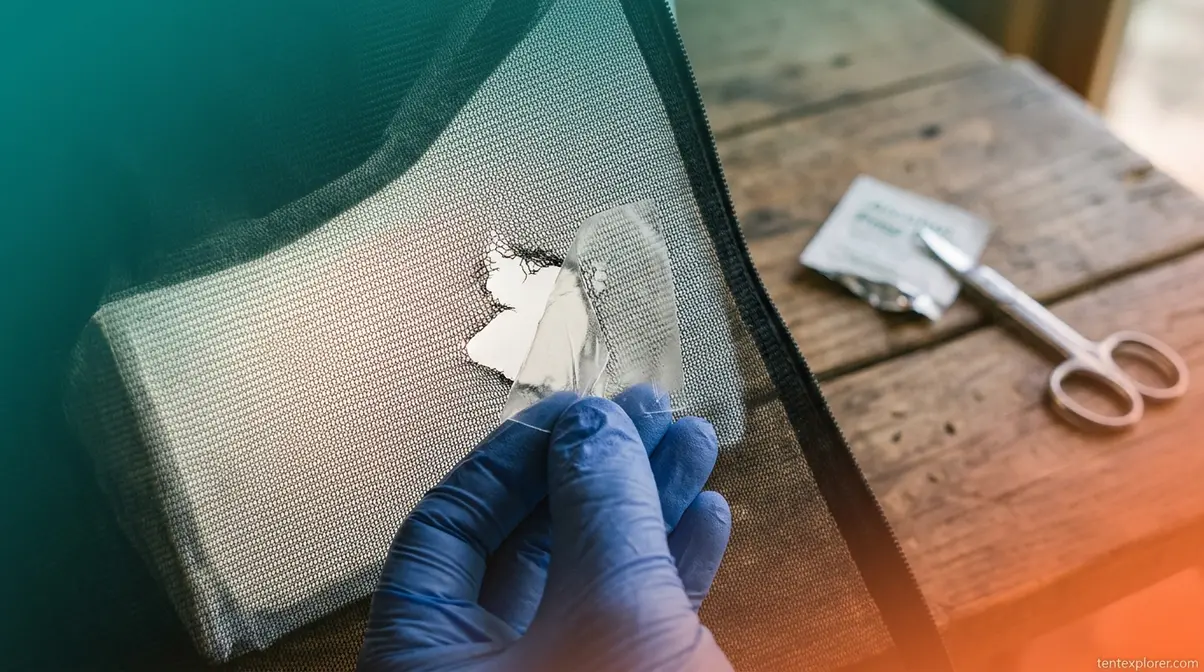 Applying Tear-Aid patch to torn tent mesh screen to stop insect entry