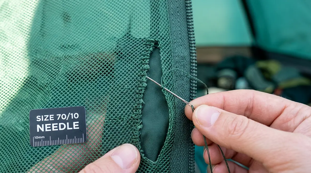 Fine size 70/10 needle sewing tent mesh with whip stitch along a large tear near zipper seam