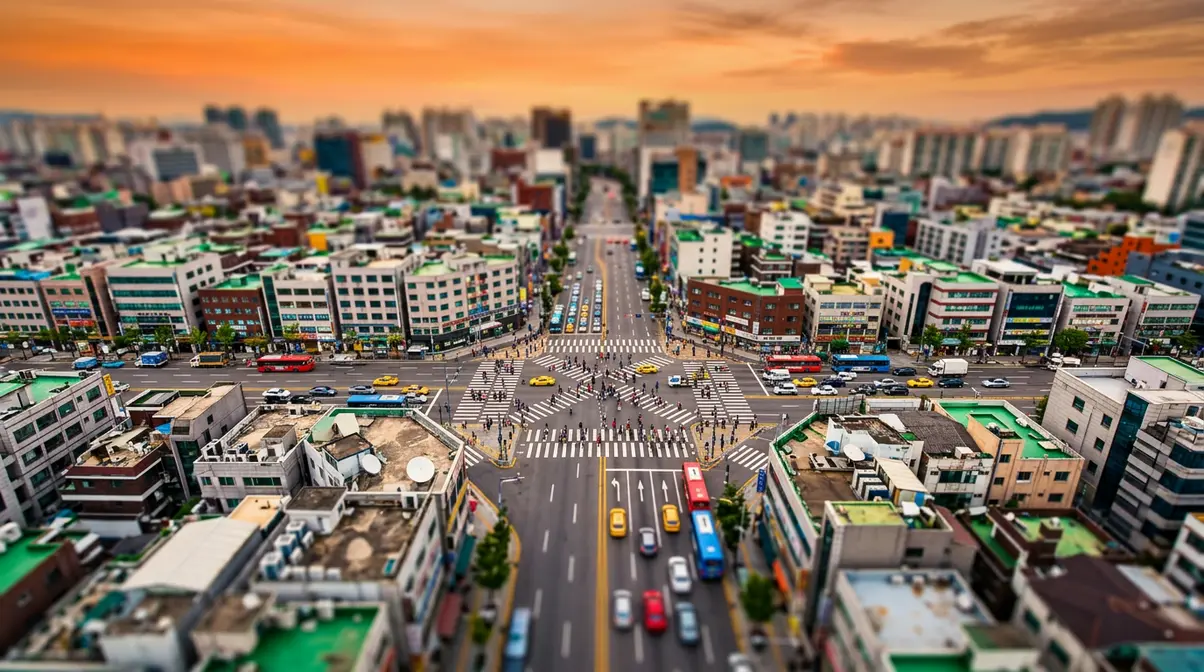 Aerial city intersection photographed with tilt-shift miniature effect showing toy-like diorama with blurred edges