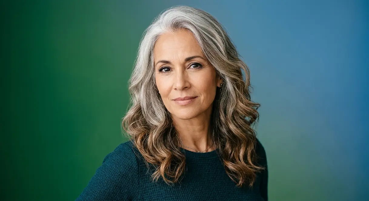 Woman transitioning to natural gray hair showing silver roots blending into highlighted ends