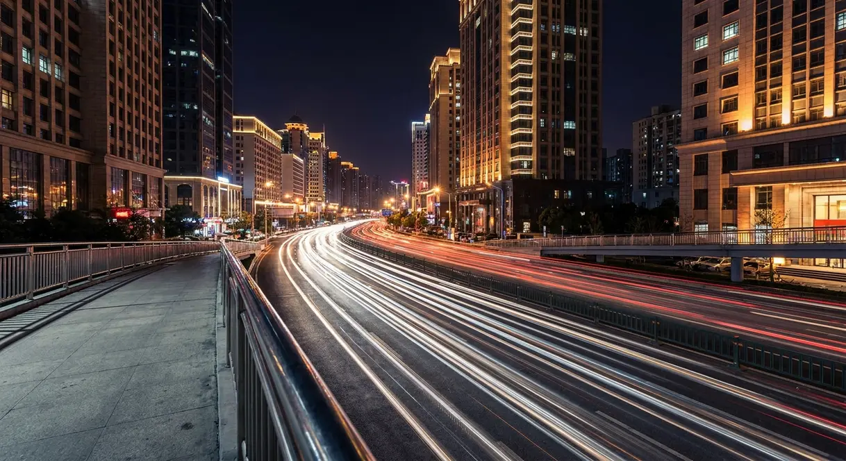 Long exposure photography showing glowing car light trails on a city road at night